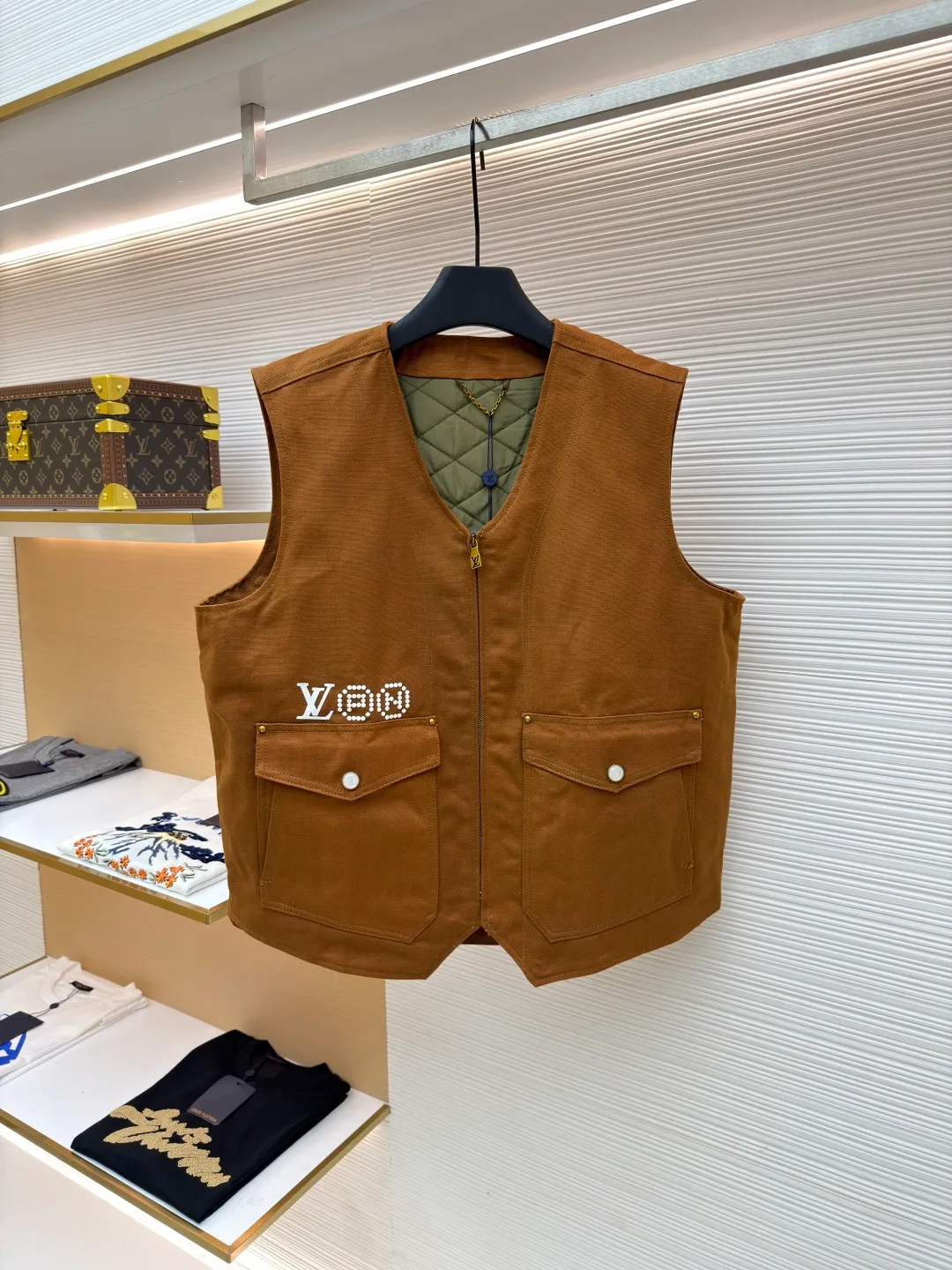 LOUIS VUITTON Nigo joint portrait work vest ●Original version: Purchased and developed for 16999 ●Item number: 1681331-B75 ●Fabric: denim fabric ●Technology: printing production ●Color: brown ●Version: fitted version ●Weight: about 785 grams ●Size: S-M-L-XL ●Description: Made of high-quality brown twill fabric, the texture is crisp and wear-resistant. The stability and texture of the fabric are ensured through fine weaving technology, which provides good support for the vest. The brand logo embroidery on the left uses a combination of bead embroidery and thread embroidery. The beads are arranged regularly, the embroidery stitches are fine, the pattern has a strong three-dimensional effect, and it is perfectly integrated with the fabric, highlighting the brand's luxurious craftsmanship. It adopts three-dimensional tailoring to fit the human body shape, making it comfortable to wear and fashionable. Double-thread reinforcement technology is used during sewing, the seams are smooth and compliant, the stitch spacing is even, and the lines are straight, reflecting the exquisite level of garment making. The buttons on the pockets are custom-made metal buttons with a smooth surface and brand details, high-quality texture and strong durability; the zipper is also customized by the brand, with the zipper puller bearing the brand logo, and the zipper is smooth and easy to pull. The quilted lining on the inside not only increases the warmth of the vest, but also improves the overall sophistication. The quilting lines are regular and reflect the meticulous craftsmanship. The design of the large pockets is both practical and decorative, with neat stitching on the edges of the pockets; the lines of the neckline and body are simple and elegant, and the overall craftsmanship details reflect the brand's high-end production standards. The overall wiring is straight and delicate, the fabric is comfortable and soft, and the color is consistent without color difference. It can be matched with the same style to create a fashionable look and control various occasions. Customized accessories, complete with three standards, same style for men and women!